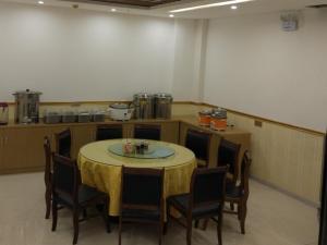 a table and chairs in a room with a table and a kitchen at GreenTree Inn Jinzhong Yuci District North Huitong Road Express Hotel in Jinzhong