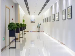 a hallway with potted plants in a building at GreenTree Inn Suzhou Kunshan Dongcheng Road International Exhibition Express Hotel in Penglang