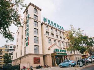 een gebouw waar een auto voor geparkeerd staat bij GreenTree Inn Chaohu West Health Road Aixin Hospital Business Hotel in Chaohu