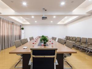 a conference room with a long table and chairs at GreenTree Inn Yancheng Tinghu Area Wanda Square Hotel in Yancheng