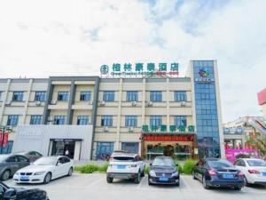 ein Gebäude mit Autos auf einem Parkplatz in der Unterkunft GreenTree Inn Suzhou Mudu Lingyan Mountain Ganglong City Hotel in Suzhou