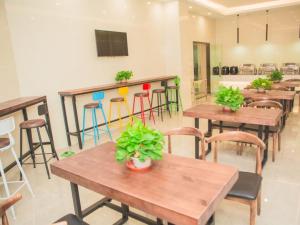 ein Restaurant mit Tischen und Stühlen mit Pflanzen darauf in der Unterkunft GreenTree Inn Yangzhou Jiangdu Xiaoji Town South Zhongxing Road Express Hotel in Xiaoji