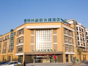 ein großes Backsteingebäude mit einem Schild darüber in der Unterkunft GreenTree Inn Yangzhou Jiangdu Xiaoji Town South Zhongxing Road Express Hotel in Xiaoji