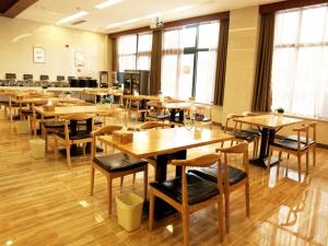 a cafeteria with wooden tables and chairs and windows at GreenTree Inn Suzhou Yongqiao District Fuxiao Avenue Hotel in Suzhou