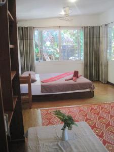 a bedroom with a bed with a monkey sitting on it at JJ Beach Resort & JJ Seafood in Ko Phayam