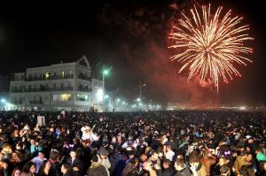 una gran multitud de personas viendo un espectáculo de fuegos artificiales en Ricky GuestHouse, en Nazaré