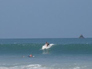 a man riding a wave on a surfboard in the ocean at JJ Beach Resort & JJ Seafood in Ko Phayam