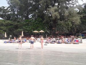 a group of people standing in the water on a beach at JJ Beach Resort & JJ Seafood in Ko Phayam