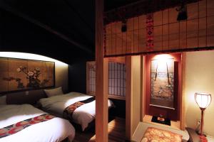 a bedroom with two beds and a lamp in it at Kyomachiya Ebisu Private Luxury Townhouse in Higashiyama in Kyoto