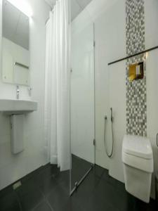 a bathroom with a shower and a toilet and a sink at Le Noor in Ernakulam