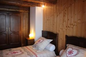 ein Schlafzimmer mit einem Bett und einer Holzwand in der Unterkunft gîte de la core in Clézentaine
