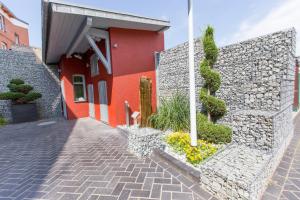 a red building with a stone wall next to a sidewalk at Aragon - Hotel - Garni in Tangermünde