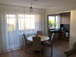 a kitchen and dining room with a table and chairs at Kesklinna Apartement in Haapsalu