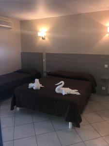 two swans on a bed in a hotel room at Hotel Clair de Lune in Zonza