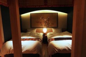 two beds in a room with a light between them at Kyomachiya Ebisu Private Luxury Townhouse in Higashiyama in Kyoto