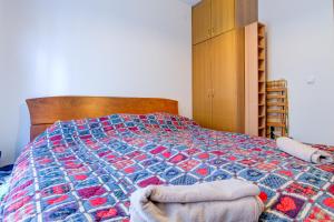 a bedroom with a bed with a colorful quilt at Allegro Apartment Sekulic in Petrovac na Moru