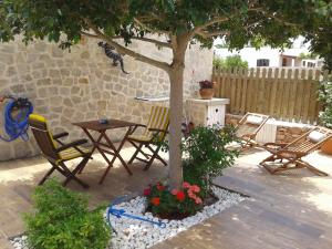 un patio con sillas, una mesa y un árbol en can jaume portas, en Sant Francesc Xavier