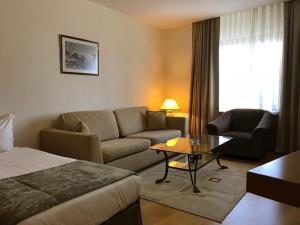 a hotel room with a bed and a couch and a table at Surmeli Istanbul Hotel in Istanbul
