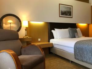 a hotel room with a bed and a chair at Surmeli Istanbul Hotel in Istanbul