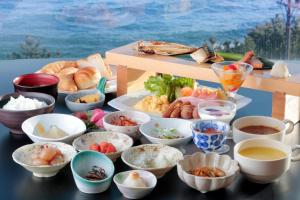a table topped with bowls of different types of food at Onahama Ocean Hotel & Golf Club in Iwaki