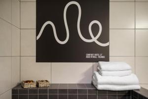 a pile of towels on a counter in a bathroom at Comfort Hotel LT - Rock 'n' Roll Vilnius in Vilnius