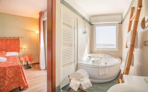 baño con bañera y lavamanos y cama en Hotel Des Nations - Vintage Hotel sul mare, en Riccione