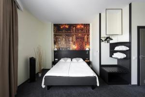 a bedroom with a bed and a painting on the wall at Comfort Hotel LT - Rock 'n' Roll Vilnius in Vilnius