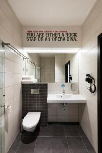 a bathroom with a toilet and a sink and a mirror at Comfort Hotel LT - Rock 'n' Roll Vilnius in Vilnius