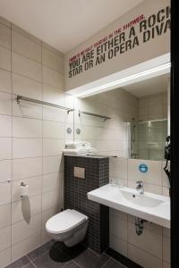 a bathroom with a toilet and a sink and a mirror at Comfort Hotel LT - Rock 'n' Roll Vilnius in Vilnius