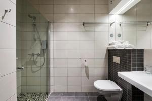 a bathroom with a shower and a toilet and a sink at Comfort Hotel LT - Rock 'n' Roll Vilnius in Vilnius