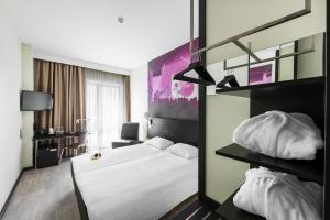 a hotel room with a white bed and a mirror at Comfort Hotel LT - Rock 'n' Roll Vilnius in Vilnius
