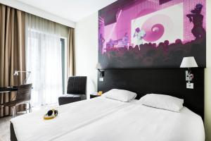 a bedroom with a large white bed and a chair at Comfort Hotel LT - Rock 'n' Roll Vilnius in Vilnius