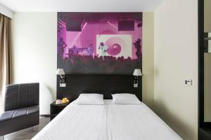 a bedroom with a bed and a pink stage at Comfort Hotel LT - Rock 'n' Roll Vilnius in Vilnius