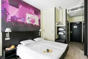 a bedroom with a large white bed with a large purple wall at Comfort Hotel LT - Rock 'n' Roll Vilnius in Vilnius