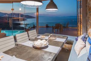 a dining room with a table and a view of the ocean at Villa Lina Syros in Azolimnos Syros