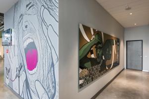 a hallway with paintings on the walls at Comfort Hotel LT - Rock 'n' Roll Vilnius in Vilnius