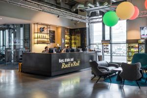 a bar in a restaurant with people sitting at a counter at Comfort Hotel LT - Rock 'n' Roll Vilnius in Vilnius