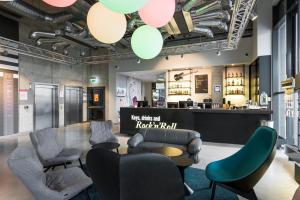 un salone con sedie e un bar sullo sfondo di Comfort Hotel LT - Rock 'n' Roll Vilnius a Vilnius