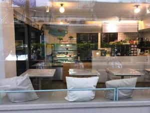 a restaurant with tables and white pillows in a window at P24 at Kaset in Bangkok