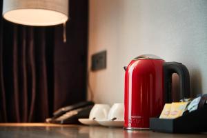 a red suitcase sitting on a table next to a lamp at South Vandeco Hotel in Busan