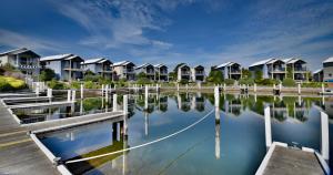 eine Reihe von Häusern auf dem Wasser mit einem Dock in der Unterkunft Captains Cove Resort - Waterfront Apartments in Paynesville