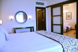 a bedroom with a white bed and a mirror at Surmeli Istanbul Hotel in Istanbul