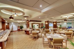 a restaurant with tables and chairs in a room at White Castle Boutique Apartment Hotel in Bangalore