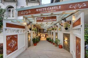 a white castle entrance to a building with potted plants at White Castle Boutique Apartment Hotel in Bangalore
