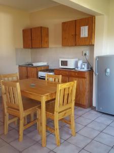 a kitchen with a wooden table and chairs and a refrigerator at White Mountain Resort in Emhubeni