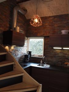 eine Küche mit Spüle und Ziegelwand in der Unterkunft Zomerhuis De Zeedistel in Egmond aan den Hoef