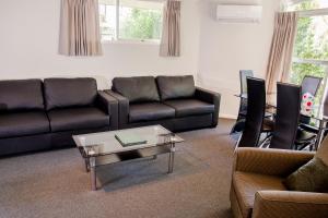 a living room with a couch and a coffee table at Ashleigh Court Motel in Christchurch
