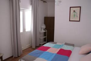 a bedroom with a bed with a colorful blanket on it at Apartment MPPM in Orebić