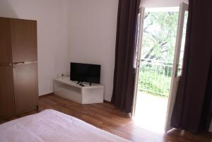 a bedroom with a television on a dresser next to a window at Apartment MPPM in Orebić