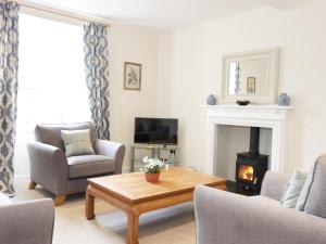 een woonkamer met een salontafel en een open haard bij The Grieves Cottage in Haddington